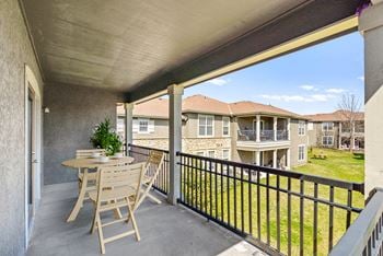A spacious, fenced-in patio overlooking a grassy area.